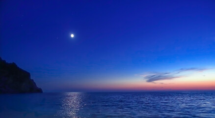 Bright full moon against the starry sky over a calm ocean 