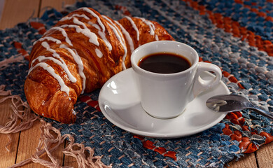 Excellent breakfast: a cup of espresso coffee and a croissant