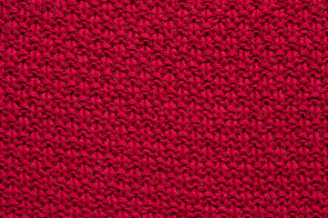 The texture of a red knitted sweater. Textured background knitting.