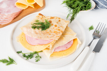 Homemade pancakes with ham and cheese on a white background, Maslenitsa