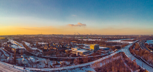 View of the snow-covered skyline of Duisburg at sunset from above