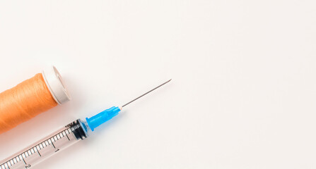Syringe with sewing thread on white background. The concept of operations and wound suturing.