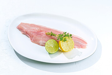 Fresh fish with lemon and lime on plate