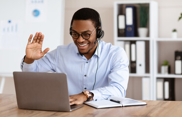 Cheerful black guy greeting business partners, having online conference