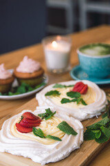 Fototapeta na wymiar Meringue and whipped cream dessert layered with seasonal strawberry.