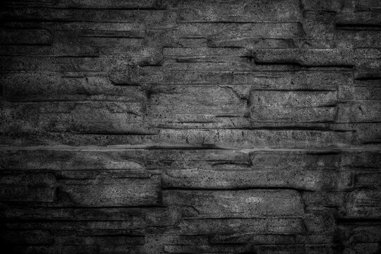Textur aus Stein oder Steinmauer als Hintergrundbild dunkel
