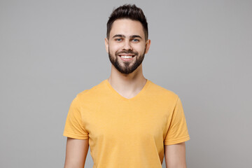 Young caucasian european smiling bearded happy attractive handsome student man 20s in casual yellow basic t-shirt look camera isolated on grey background studio portrait People lifestyle concept.