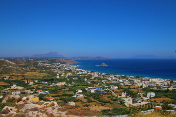 Naklejka premium Beach framed by cliffs on beautiful island Majorca. Nice sunset on beach with trees in nature outside in Spain. Beautiful blue water and white sand beach. white houses on the cliffs.