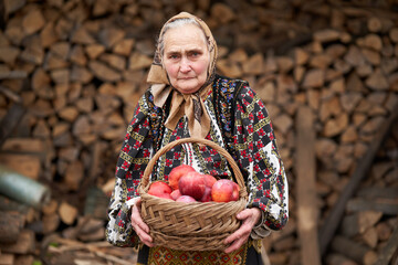 Old woman with a basket of apples outdoor