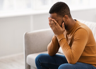 Desperate African Man Covering Face Crying Having Depression At Home