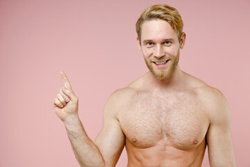 Smiling bearded naked young man 20s years old perfect skin pointing index finger aside up isolated...
