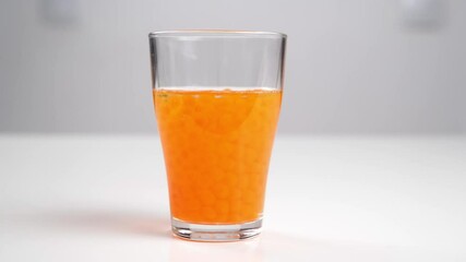 Orbeez - balls that grow in water pour into a glass of water.