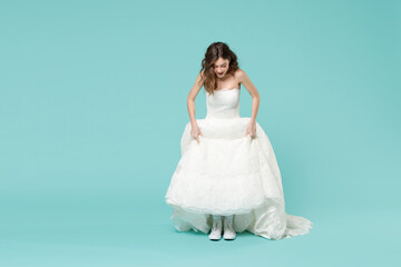 Full length excited bride brunette woman 20s in beautiful white wedding dress casual gumshoes...