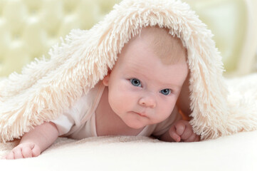 cute little baby girl playing under the blanket