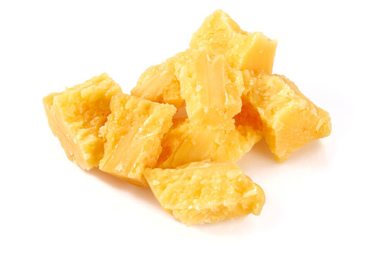 broken pieces of hard cheese isolated on white background