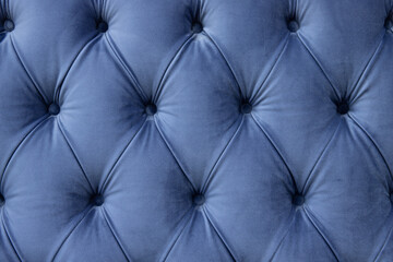 luxury seamless background of velvet blue fabric on upholstered furniture close-up