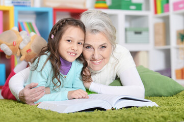 Fototapeta na wymiar Grandmother reading book with granddaughter