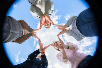 A friendly family makes a star shape out of their hands.