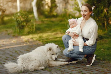 Mother with daughter. Family in a park. Newborn girl. Cute dog.