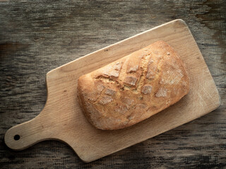 Bread, freshly baked at home, put on a wooden board and in a metal form.