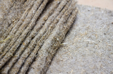 Selective focus on structure of linen seedling mats. Texture of substrate for growing microgreens. Organic substrate for sowing green seeds. Pile of folded linen fiber rugs.