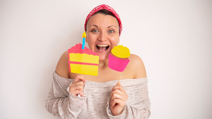Portrait of a happy woman holding a piece of cake and cupcake.
