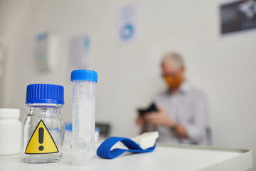 Close up background image of bio samples with warning sign on desk in doctors office, copy space