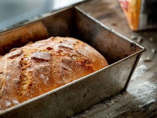 Bread, freshly baked at home, put on a wooden board and in a metal form.