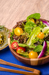 Healthy organic fresh vegetable salad, fresh leaves mix salad in wooden bowl on wooden table Healthy and Diet food.