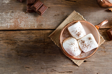 Obraz na płótnie Canvas The dessert food vintage style : The Marshmallow with hot chocolate in copper cup on the wooden table. Background copy space for copy text