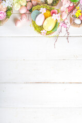 Happy easter background with Nests decoration, colorful eggs and Spring Flowers. Caster card on sunny spring background