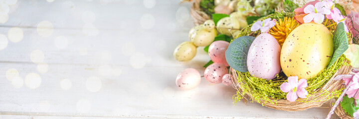 Happy easter background with Nests decoration, colorful eggs and Spring Flowers. Caster card on sunny spring background