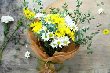 Fototapeta na wymiar Bouquet daisy chamomile flowers on wooden garden table.