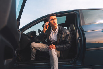Young caucasian man inside a car using a smartphone