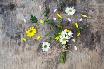 Obraz premium Bouquet daisy chamomile flowers on wooden garden table.
