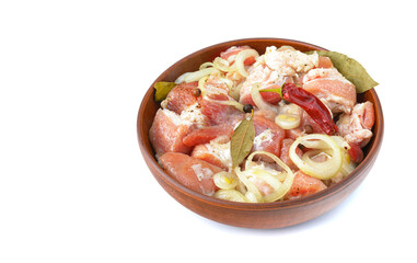 Pork ribs, sliced and marinated with onions, meat in a clay bowl, white isolated background, close-up, Selective focus.
