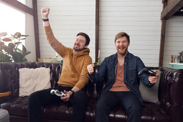 Men play game console and emotionally rejoice at victory, fun time at home