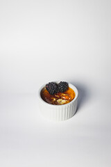 Creme Brûlée with fresh Blackberries. Photo was taken with white background and single light source gourmet style.