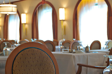 Formal dining room or restaurant with set tables onboard classic cruiseship or cruise ship liner...