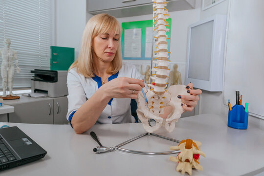Doctor physiotherapist explaining the mechanism of injury using vertebra model