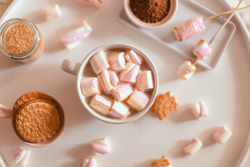 Delicious sweet aromatic cocoa drink with marshmallow sweets in a mug on the white table. Flat lay, top view. Warming Christmas winter drink
