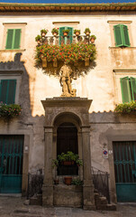 Fototapeta na wymiar A building in Piazza San Michele in the historic medieval village of Santa Fiora in Grosseto Province, Tuscany. It is the location of an earlier church and features a statue of Saint Michael