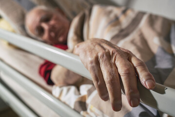 Old man lying in medical bed