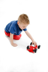 Cute little boy child kid preschooler playing with car toy. Isolated on white background 
