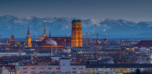 Munich city skyline aerial view at night, marienplatz square church frauenkirch, alps montains.