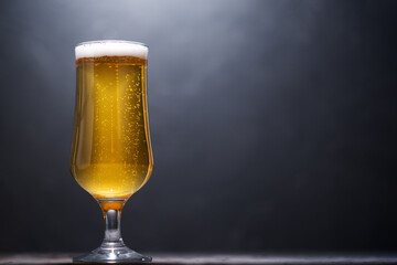 A glass of light beer on a concrete table in the bar, copy space