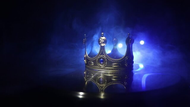 low key image of beautiful queen/king crown over wooden table. vintage filtered. fantasy medieval period. Selective focus. Colorful backlight