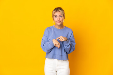 Young Russian woman isolated on yellow background making the gesture of being late