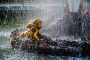 Detalle del agua cayendo cerca de la estatua de un querubín en los jardines del Palacio de...