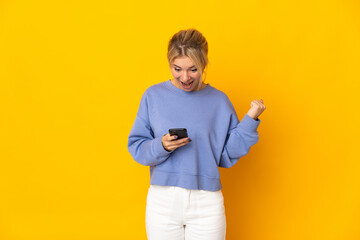 Young Russian woman isolated on yellow background surprised and sending a message
